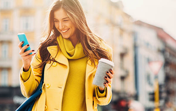 women on cell phone with coffee